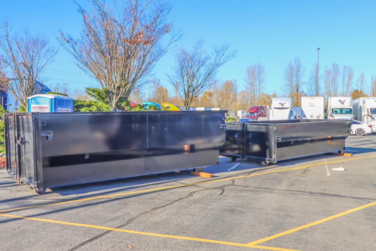 Professional dumpster rental service with roll-off container on residential driveway in East Moline